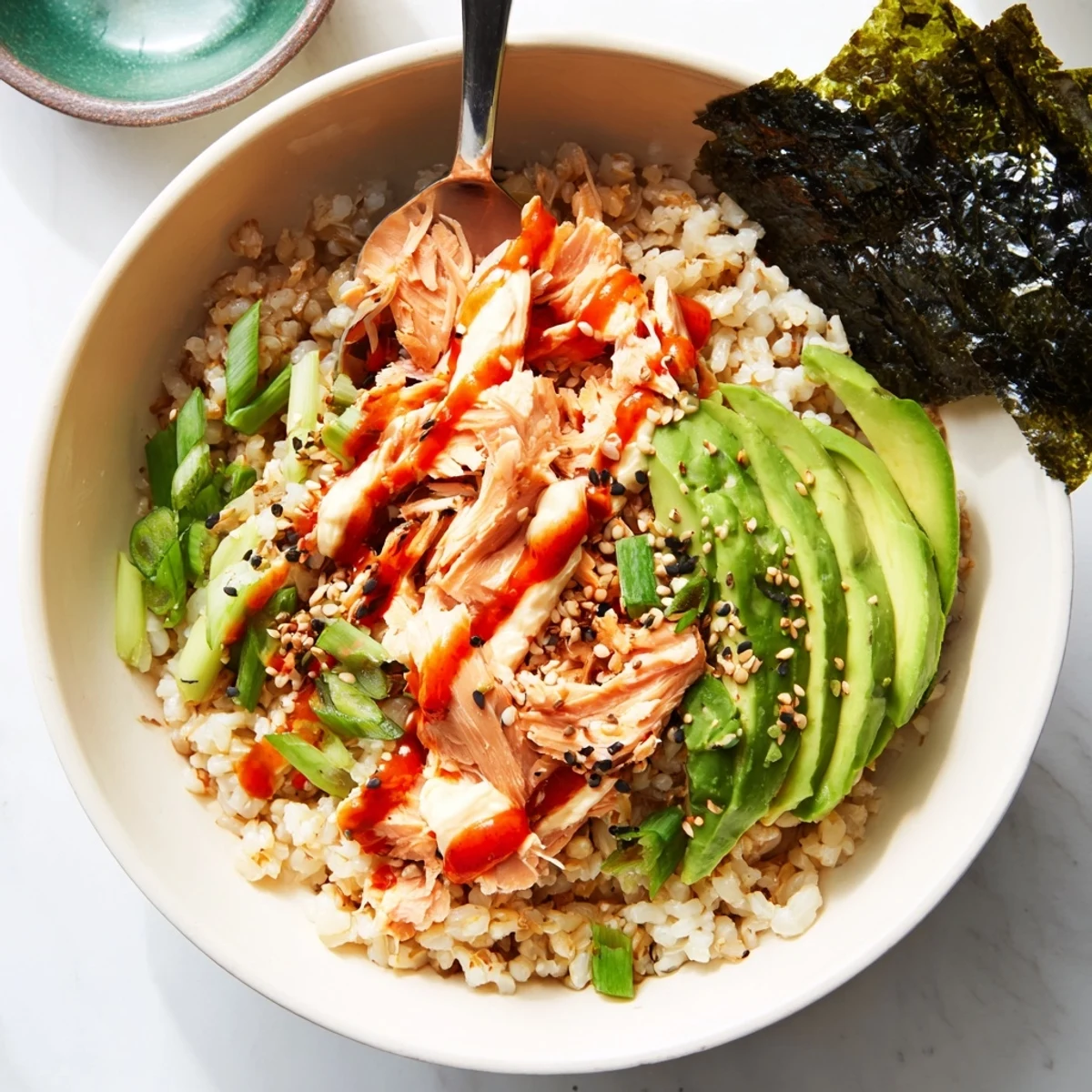 Close-up of a comforting Emily Mariko Salmon Rice Bowl featuring tender salmon, seasoned rice, and avocado, ready for a quick meal.