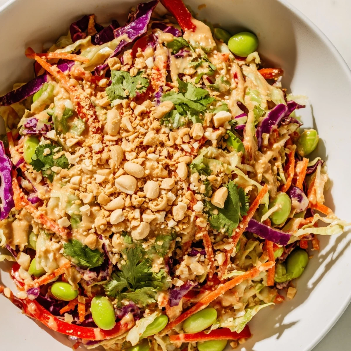 Vibrant Crunchy Thai Peanut Salad served fresh, featuring crisp cabbage, red bell pepper, and sesame seeds, making it a refreshing vegan side or light meal for a healthy lunch.