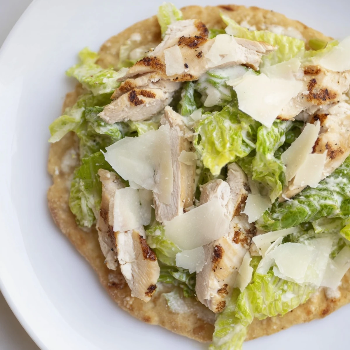 Warm, crisp Chicken Caesar Flatbread served with tangy dressing and crunchy lettuce.