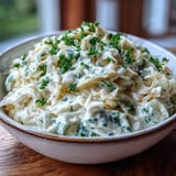 Golden Creamed Cabbage served steaming hot as a comforting side dish with fresh parsley garnish.