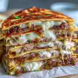 Golden, crispy Cheesy Griddled Smashburger Quesadilla wedges served on a white plate with a bowl of tangy mayo-mustard dipping sauce.