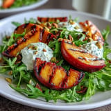 Juicy grilled peaches and creamy burrata create a stunning, light salad delight.