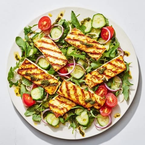 This plate of grilled halloumi and pesto features perfectly grilled cheese and garden-fresh vegetables.