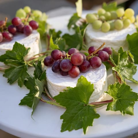 The Rustic Vineyard displays young cheese with grapes and vines, ready for an easy, shareable appetizer gathering.