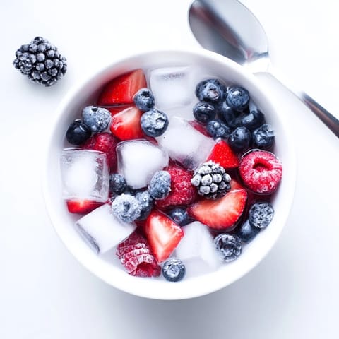 A colorful, hydrating Natures Cereal Bowl garnished with fresh berries and crisp ice cubes.  