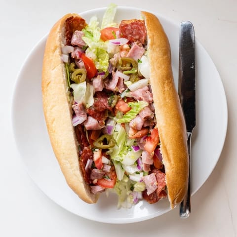 Savory chopped Italian meats and melted provolone cheese stuffed in a golden toasted hoagie roll, garnished with fresh diced tomatoes and red onion.  