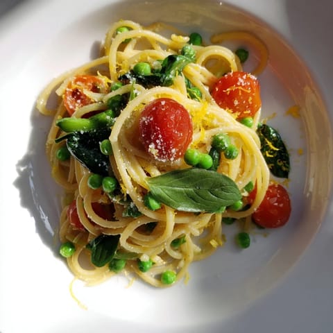Spring Veggie One-Pot Spaghetti is garnished with fresh basil and grated Parmesan for a bright, Italian-inspired finish.
