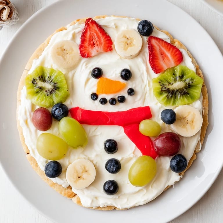 Delicious slices of Melting Snowman Fruit Pizza, a fun and easy dessert for your winter gatherings.