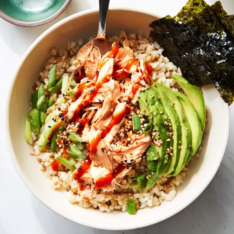 Close-up of a comforting Emily Mariko Salmon Rice Bowl featuring tender salmon, seasoned rice, and avocado, ready for a quick meal.