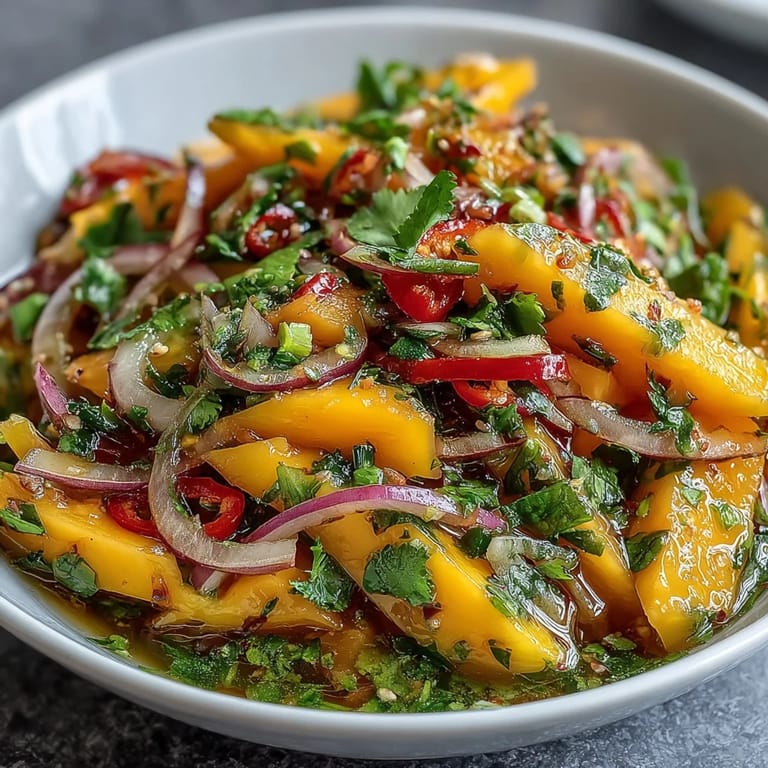 Juicy mango pieces mingle with crisp vegetables in this Thai-inspired salad, with lime wedges on the side for a bright citrus finish.