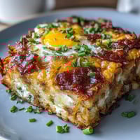 Hearty Amish breakfast casserole with hash browns, eggs, and sausage baked until golden and bubbling with melted cheese.
