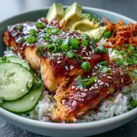 Vibrant teriyaki salmon bowl with glazed fillets, fresh avocado, crisp cucumber, and sesame rice — a quick, healthy dinner ready in 15 minutes.