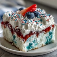 Memorial Day Red White Blue Poke Cake with vibrant red and blue gelatin swirls and creamy whipped topping.
